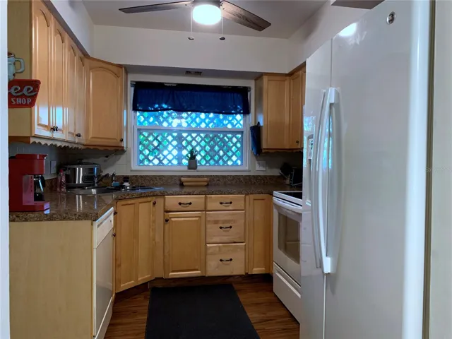 Kitchen with decent cabinet space, dishwasher, disposal, range, microwave and fridge/freezer. The window looks out over a little bistro seating area behind the Bleeding Heart vine out front; can't see into this space from the outside.