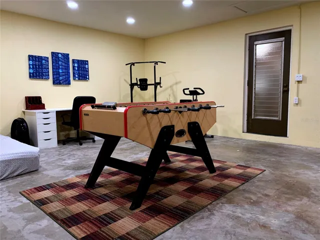 Bonus room with foosball, a full size desk and rolling leather chair, pull-up stand, pedal bike, and King sized divan.