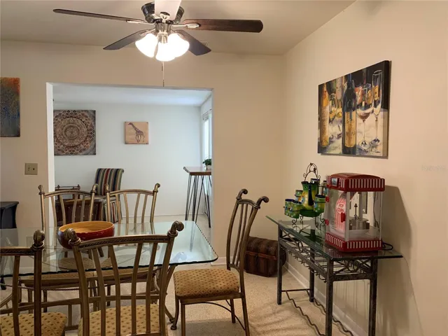 Console table on the wall has a popcorn machine and room to store wine bottles and glasses. Florida room in the background; the door to the back yard is just barely visible to the right of the Florida room.