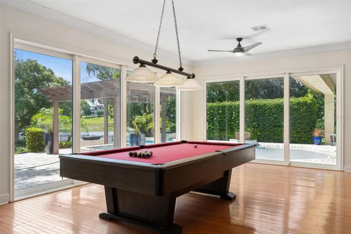 Game area of the GREAT ROOM.  Large Sliding doors to open up the fresh air and always the view of the Lake and natural light