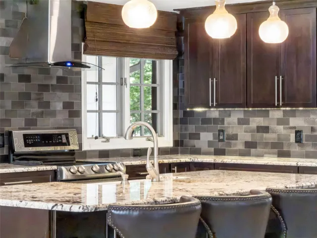 Under cabinet lighting, Stainless exhaust and Natural light enhance the kitchen.