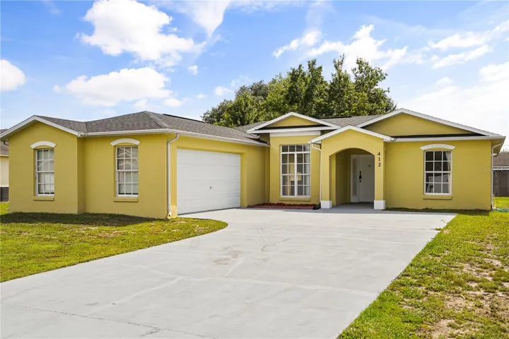 Charming Poinciana curb appeal featuring a brand-new roof and a low-maintenance front yard.