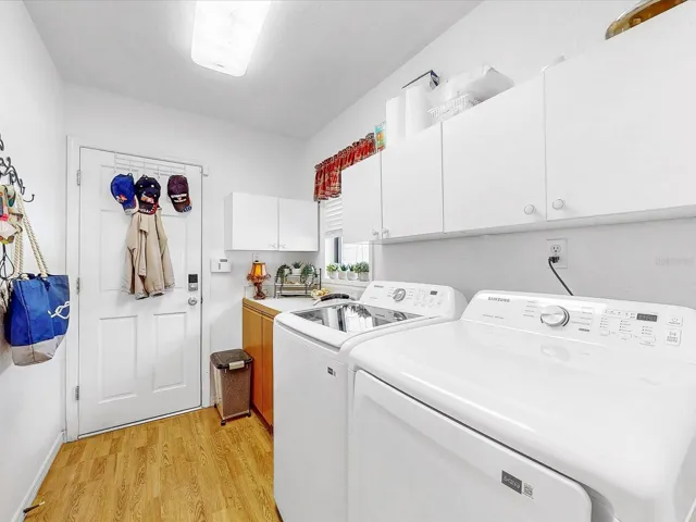 The laundry room. Upper cabinets and a folding counter with cabinets below for storage