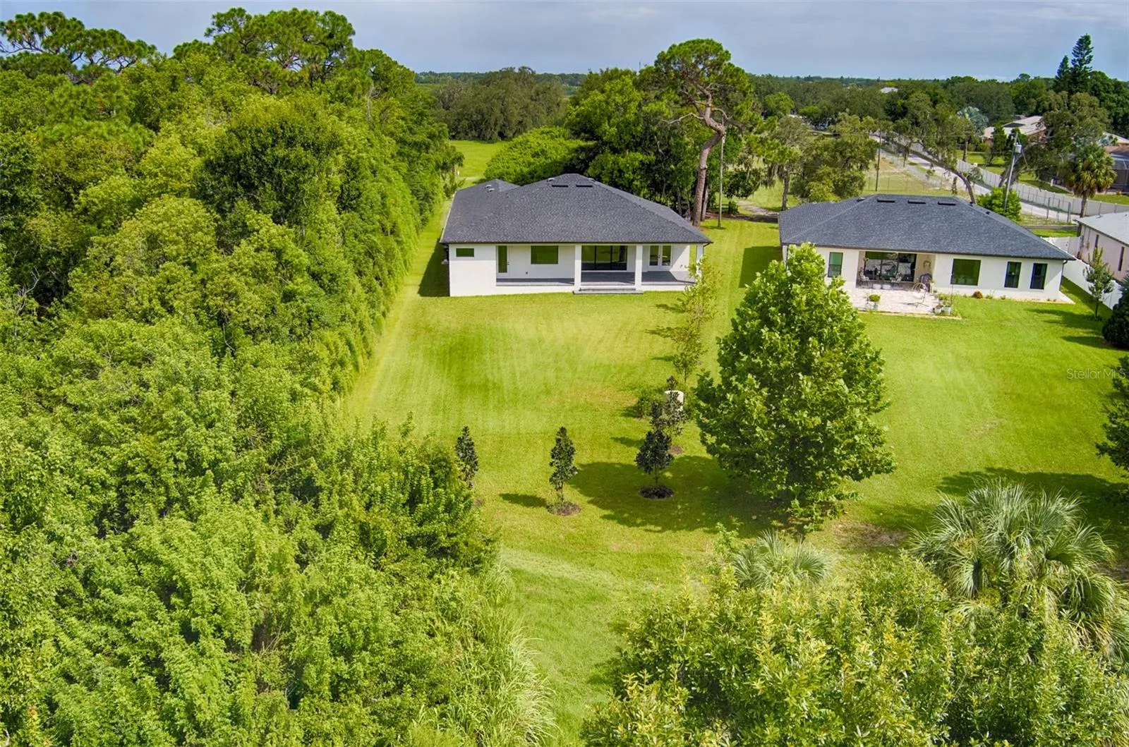 Aerial view of the expansive backyard, offering plenty of open green space and a peaceful, private setting surrounded by lush nature. Imagine adding a pool, a playground, an outdoor kitchen, or your own backyard oasis—the possibilities are endless!