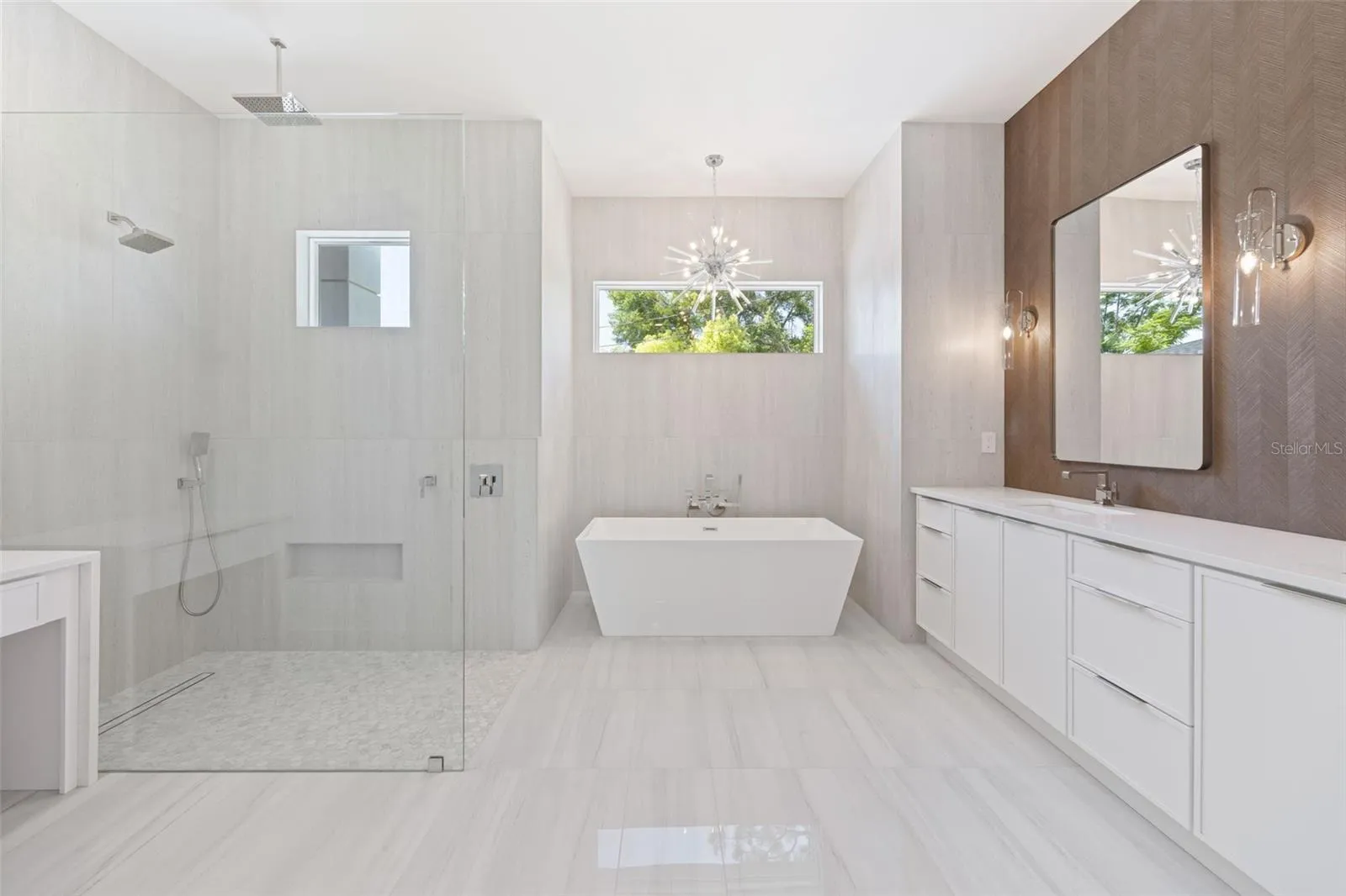 The luxurious primary suite offers a spa-inspired retreat featuring a freestanding soaking tub, oversized walk-in shower with rain head and handheld shower, premium Italian tile, designer fixtures, and thoughtful custom details throughout.
