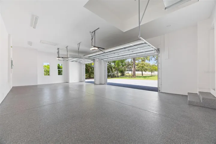 Oversized 3-car garage with industrial-grade epoxy flooring, Wi-Fi garage door openers, and impressive 11-foot ceilings.