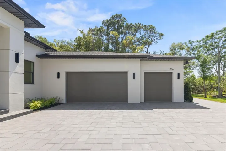 Modern paver driveway with turnaround area and additional parking space.