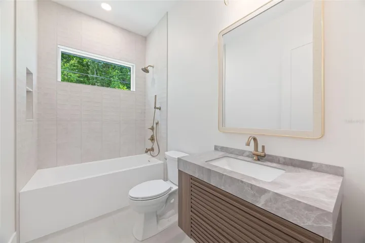 The 2nd full bathroom showcases oversized Italian tile, designer-selected fixtures, and elegant finishes consistent with the home's custom craftsmanship.