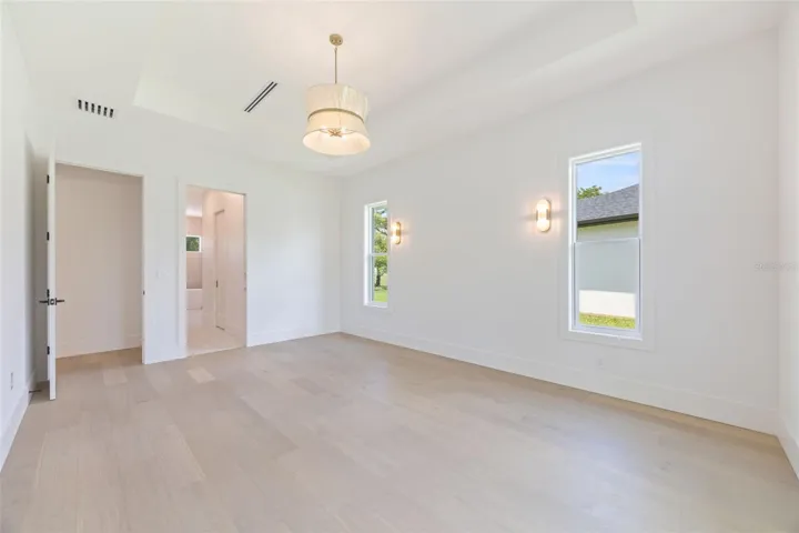 The luxurious primary suite offers a spa-inspired retreat featuring a freestanding soaking tub, oversized walk-in shower with rain head and handheld shower, premium Italian tile, designer fixtures, and thoughtful custom details throughout.