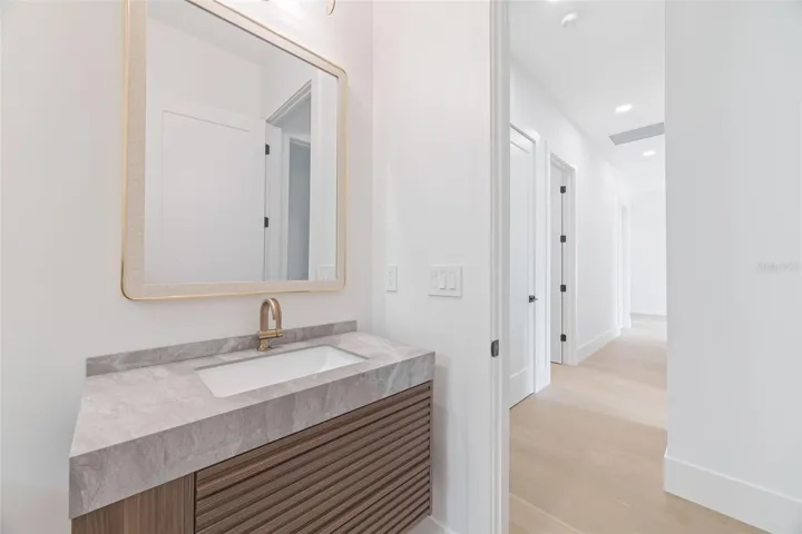 The 2nd full bathroom showcases oversized Italian tile, designer-selected fixtures, and elegant finishes consistent with the home's custom craftsmanship.