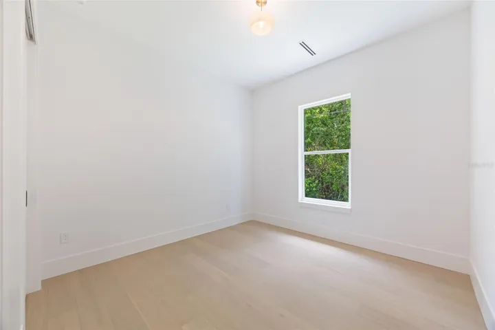 Spacious bedroom 3 with impact-rated window, solid-core door, and convenient access to a full bath.