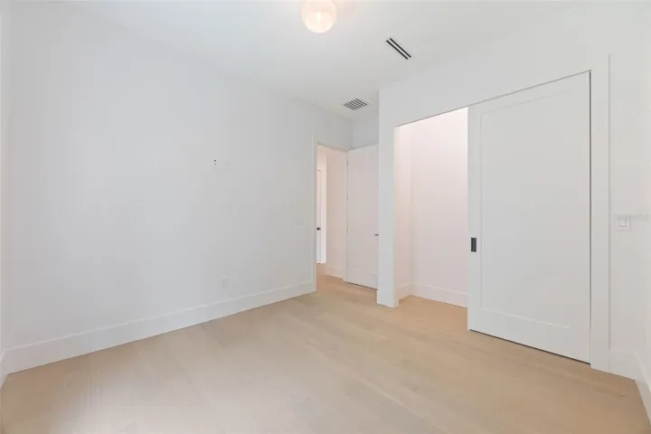 Spacious bedroom 3 with impact-rated window, solid-core door, and convenient access to a full bath.