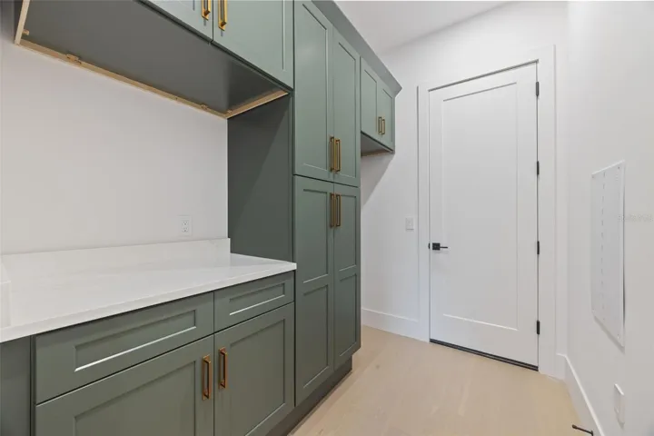 Designed with both beauty and functionality in mind, the laundry room offers elegant Shaker Ivy cabinetry, abundant storage with tall cabinets, stackable washer and dryer hookups, and a pre-plumbed sink base cabinet.