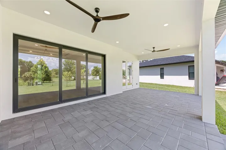 Covered paver lanai, pre-plumbed for a future outdoor kitchen, overlooking the beautifully landscaped yard with premium St. Augustine sod and mature native pine trees.