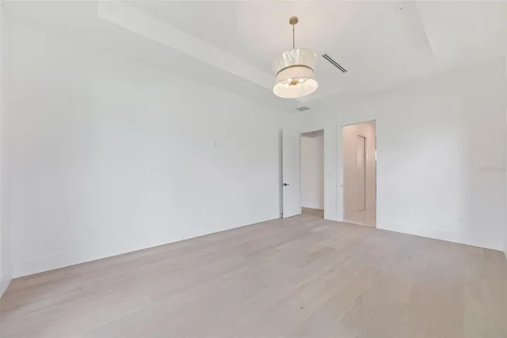 The luxurious primary suite offers a spa-inspired retreat featuring a freestanding soaking tub, oversized walk-in shower with rain head and handheld shower, premium Italian tile, designer fixtures, and thoughtful custom details throughout.