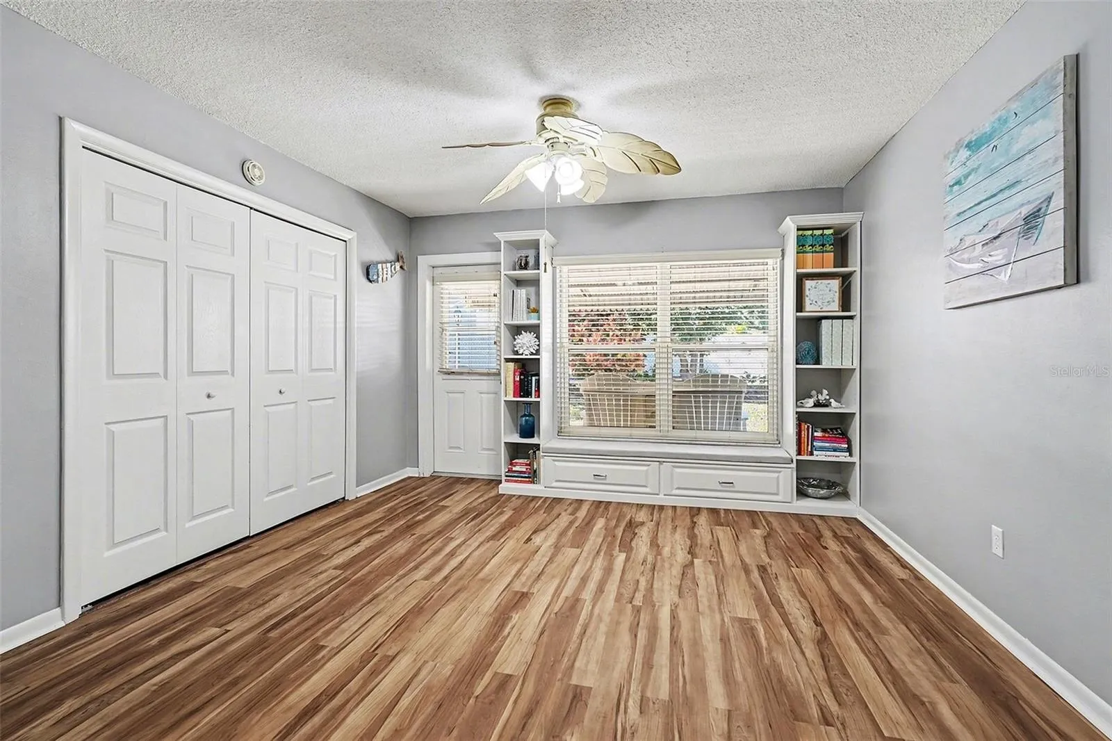 Florida room showing custom build in designer shelving with window seat and cabinets.