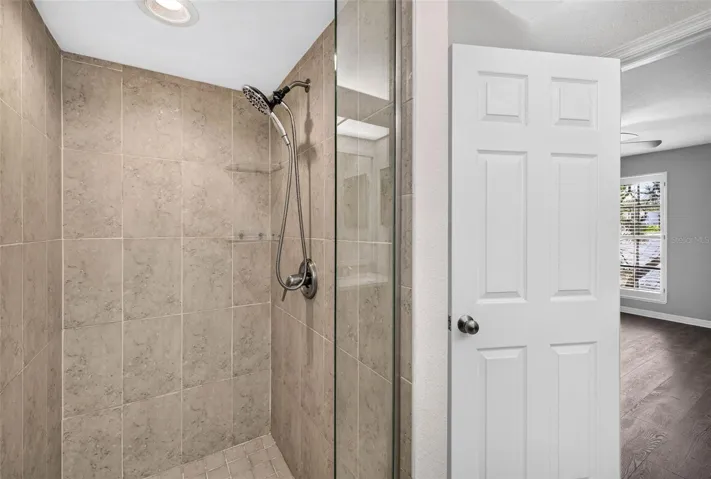 Glass enclosed shower with foot to ceiling tile