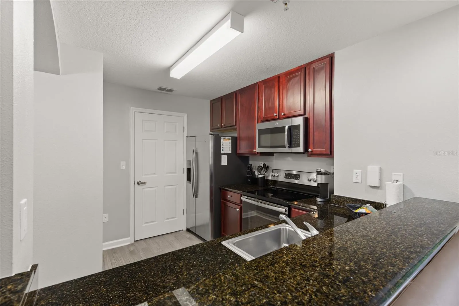 Kitchen Has Granite Countertops & Long Bar Counter Space