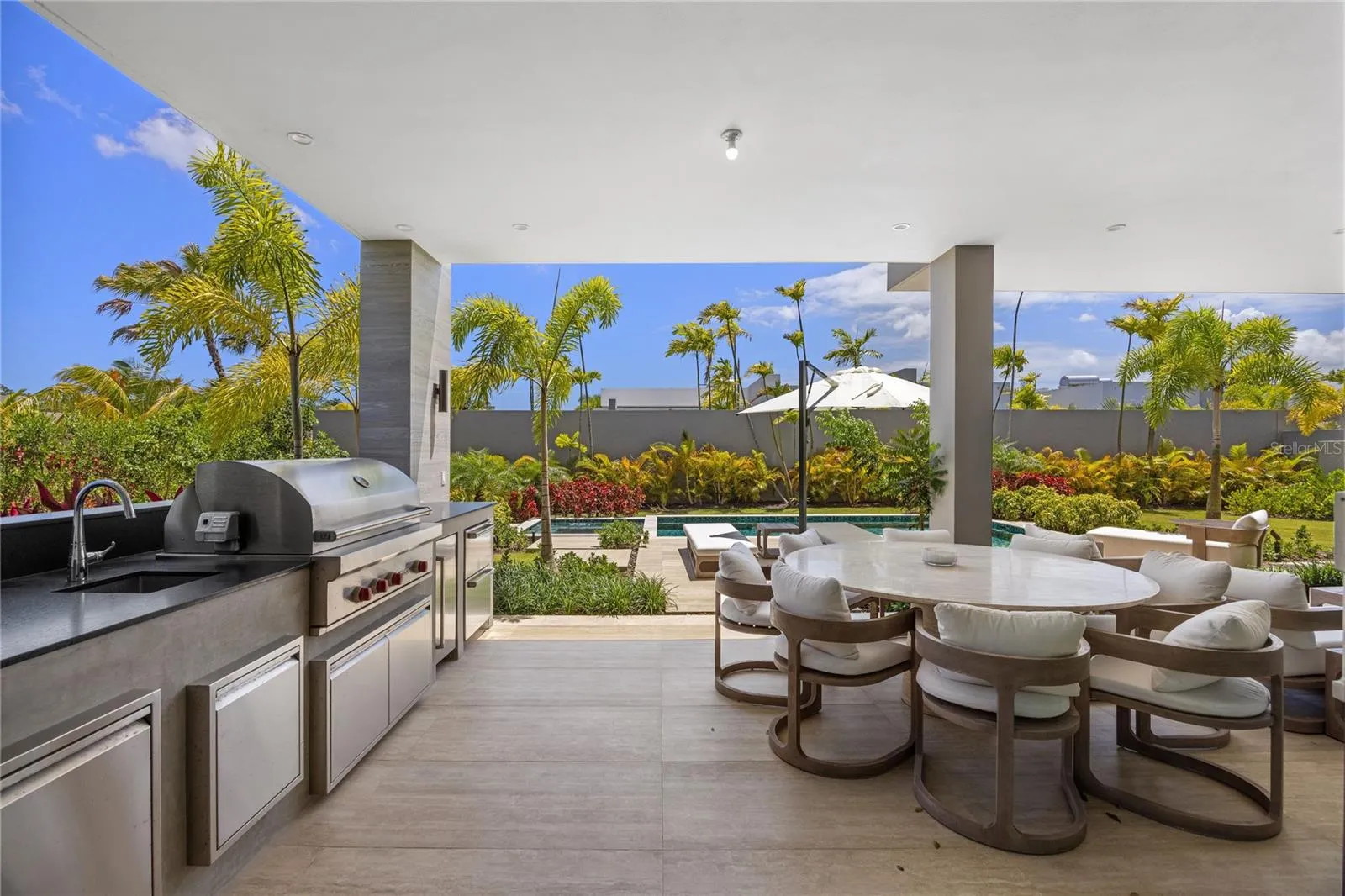 Designed for effortless indoor-outdoor living, the covered terrace serves as an extension of the home's entertaining space. Complete with a built-in BBQ, ice maker, dual refrigerator drawers, and an integrated outdoor sound system, it overlooks the private pool, jacuzzi, outdoor shower, and pool bath, creating the ultimate setting for gatherings or relaxing afternoons at home.