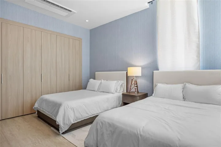 The second floor features three generously sized bedrooms, each with its own en-suite bathroom, ample closet space, and television. A conveniently located laundry room is also situated on the upper level.