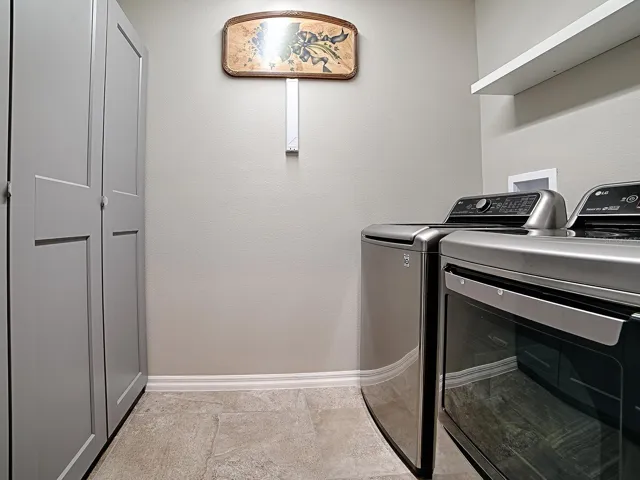 INDOOR LAUNDRY ROOM WITH EXTRA STORAGE CABINETS LOCATED IN THE HALLWAY TO THE KITCHEN.  WASHER AND DRYER DO CONVEY WITH THE HOME. THIS ROOM HAS BEEN PLUMBED FOR A SINK.
