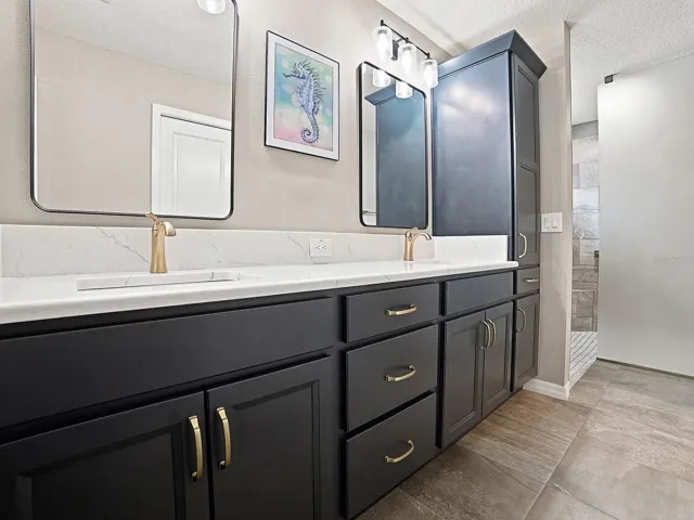 LOVELY CHAMPAGNE BRONZE HARDWARE, DUAL SINKS, QUARTZ COUNTERTOPS, LINEN CLOSET, AND ROMAN WALK-IN SHOWER.