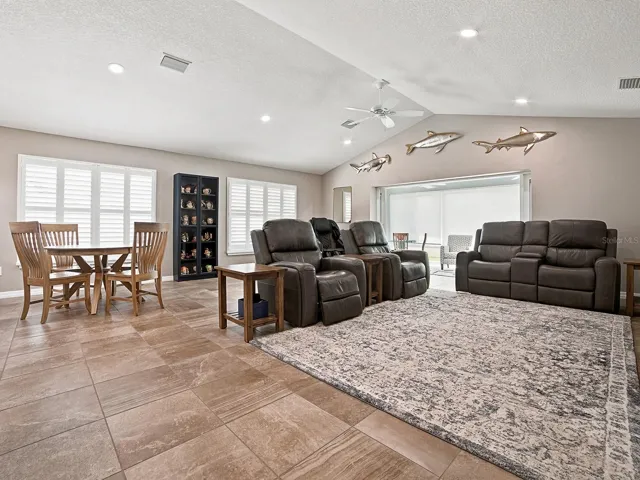 STACKBACK SLIDING GLASS DOORS OPEN TO THE GLASS ENCLOSED LANAI.