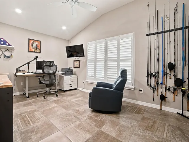 2ND GUEST ROOM BEING USED AS AN OFFICE AND MAN CAVE WITH PLANTATION SHUTTERS, AND VAULTED CEILING.