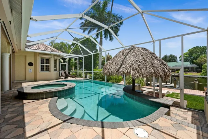 Pool surrounded by pavers and screened in