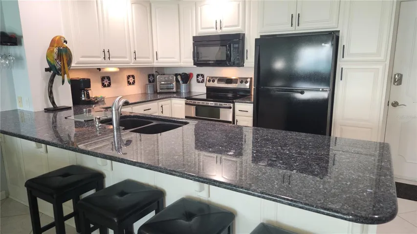 Beautiful upgrades to the kitchen include black and stainless steel appliances, a granite cooktop and custom cabinetry