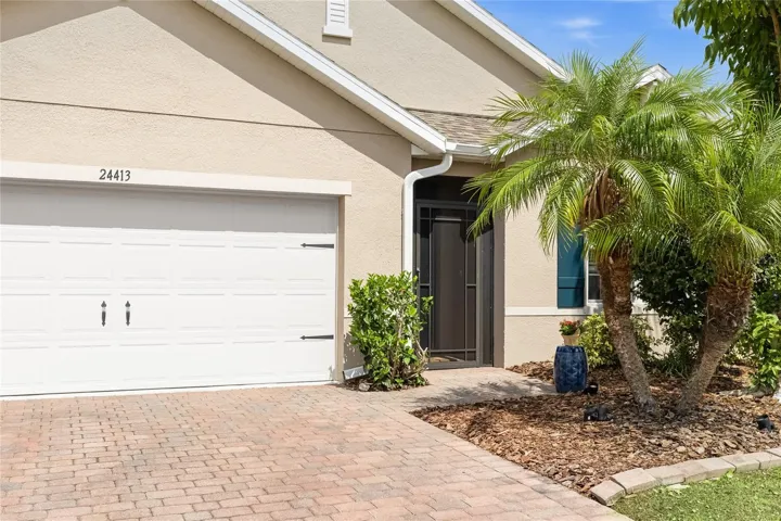 Front of home with Lush Landscaping and screen enclosed foyer.