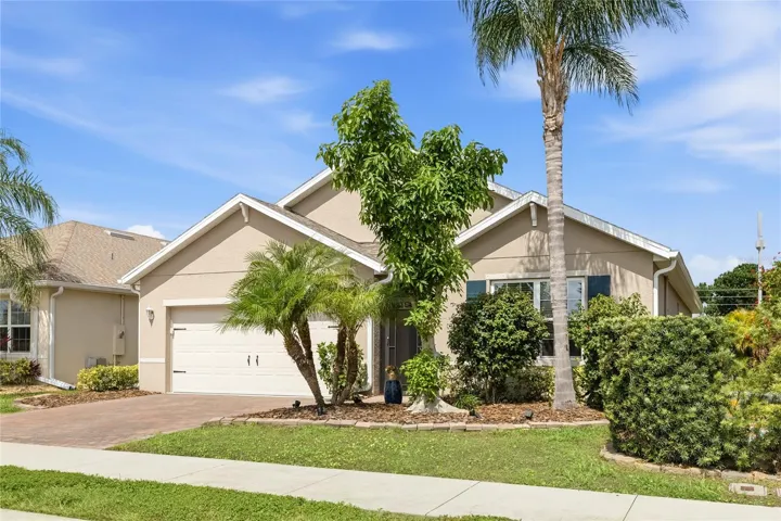 Front of home with Lush Landscaping and screen enclosed foyer.