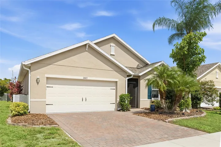 Front of home with Lush Landscaping and screen enclosed foyer.
