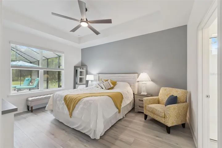Spacious Primary Bedroom with Tray Ceilings & Pool and Water Views