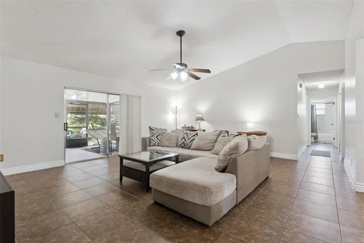 Living Room with view to the hallway to bedrooms and bath and view to lanai and backyard