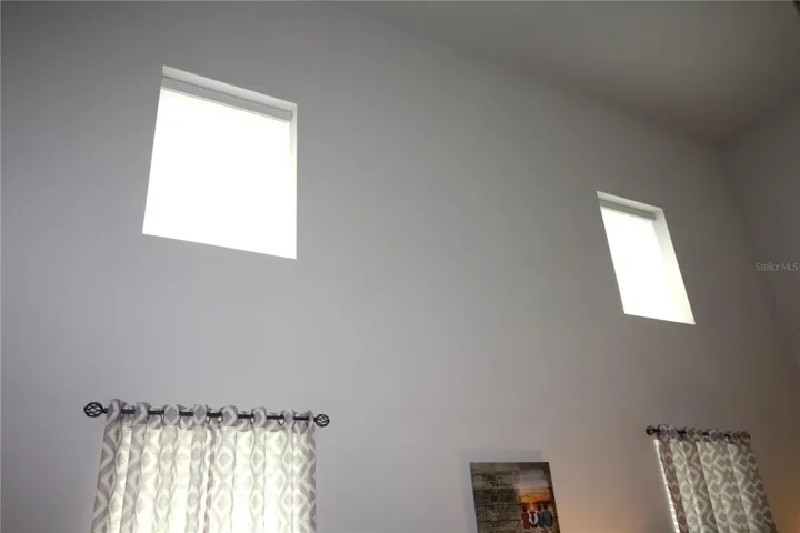 these two high windows have remote controlled blinds