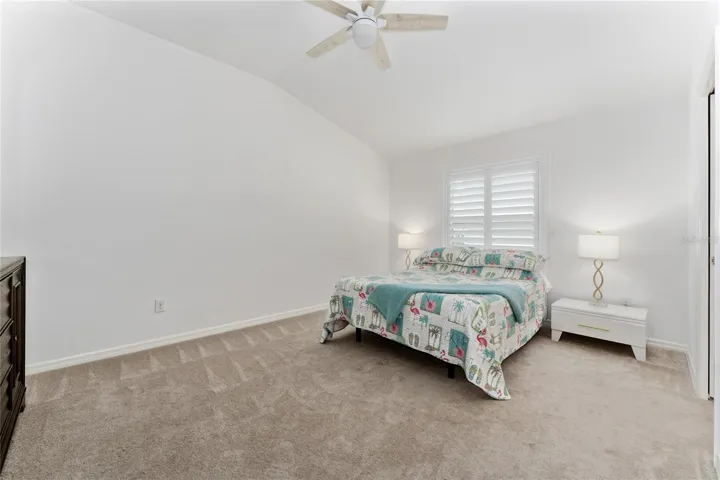 Primary bedroom in the Emerald IV with carpet and ceiling fan with light.