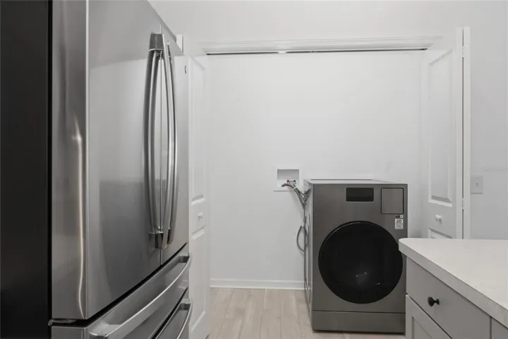 Laundry closet off the kitchen with Samsung all-in-one washer/dryer.