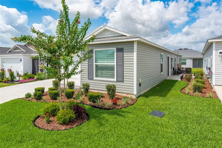 Side exterior with golf cart garage and concrete side patio.