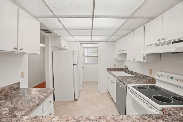 Room to Spread Out. Cabinetry and counter space line both sides of the kitchen, while the wide breakfast bar opens the space to the dining and living areas.