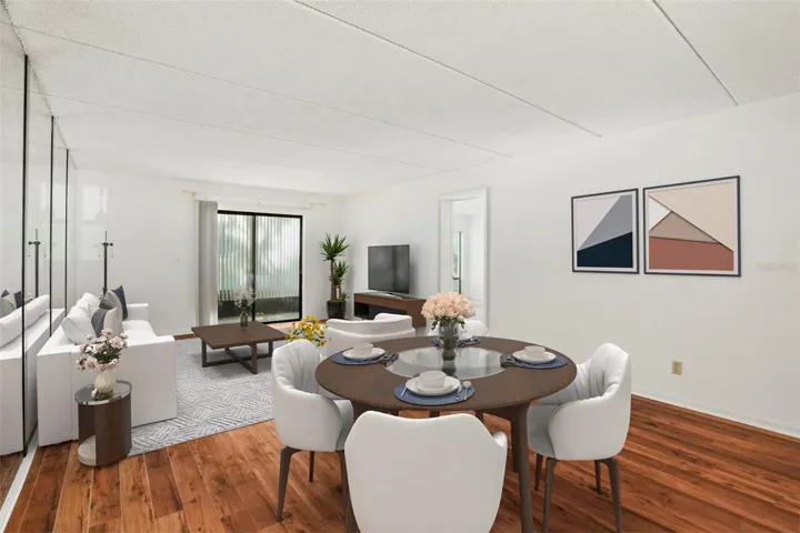 Spacious Living. Laminate flooring, expansive living and dining space, and a mirrored accent wall reflect natural light while enhancing the room's sense of openness.