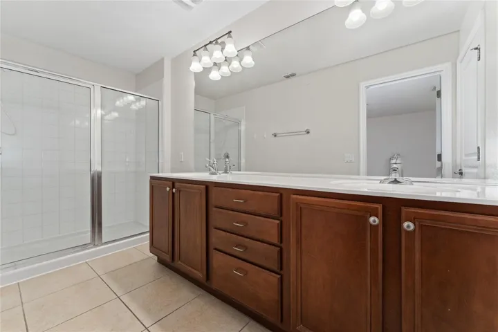 Master bathroom with dual sinks and walk-in shower