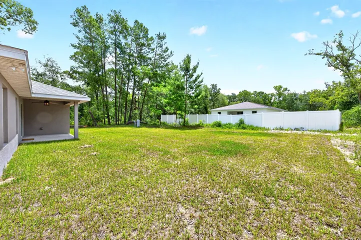 The expansive backyard offers endless possibilities for outdoor living, gardening, recreation, or simply enjoying the peaceful surroundings and wide-open space.