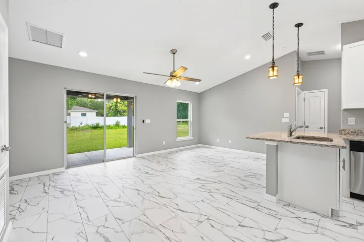 The Kitchen overlooks the spacious Living Room where you'll enjoy a sleek ceiling fan, ABUNDANT NATURAL LIGHT, and sliding glass doors that open to the covered patio.