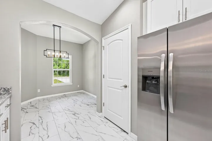 An ELEGANT ARCHED DOORWAY leads into the heart of the home, the Kitchen and Living Room.