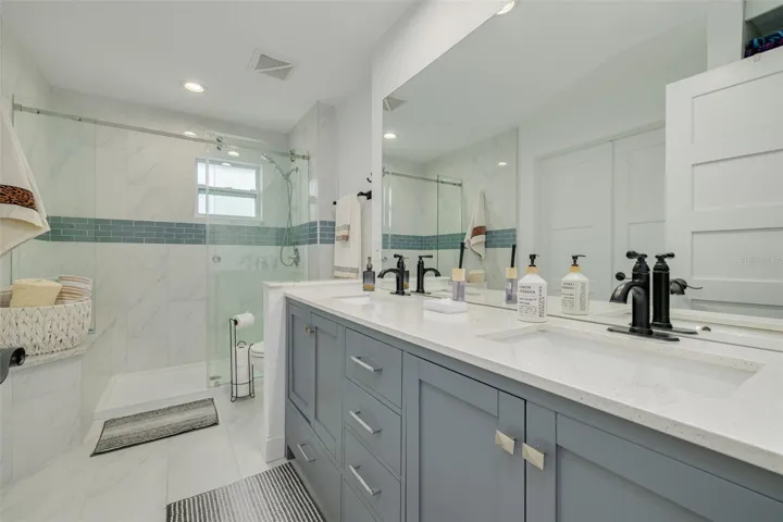 Remodeled bathroom with double-sink vanity and a spacious walk-in shower