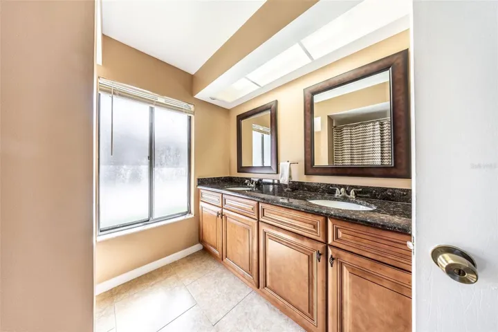 Primary en-suite with dual vanity sinks and granite counters