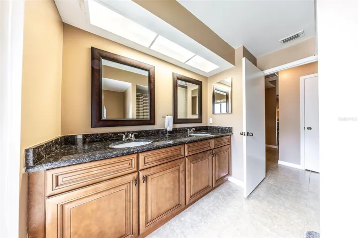 Full bathroom 2 with dual vanities and granite counters