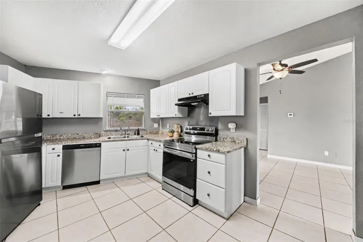 The updated kitchen features shaker-style cabinets, granite countertops, and stainless steel appliances.