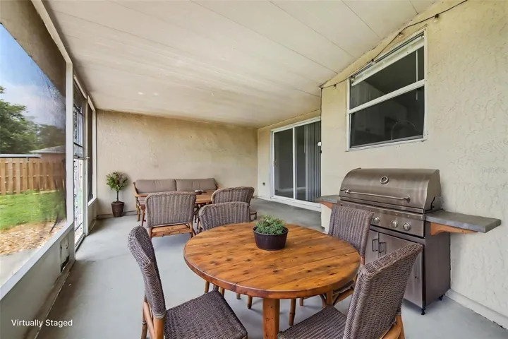 Extended living space is achieved with this screened patio  -  ideal for relaxing, dining, or enjoying Florida living without the bugs.